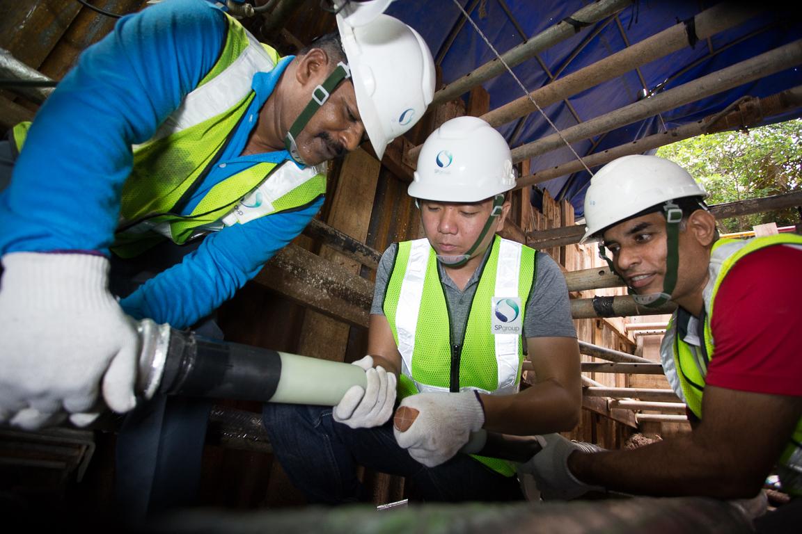 Hands on: Getting down to business doing cable jointing in the trench with his colleagues Krishnasamy Shanmuguraj (left) and Sanjay Kumar (right).