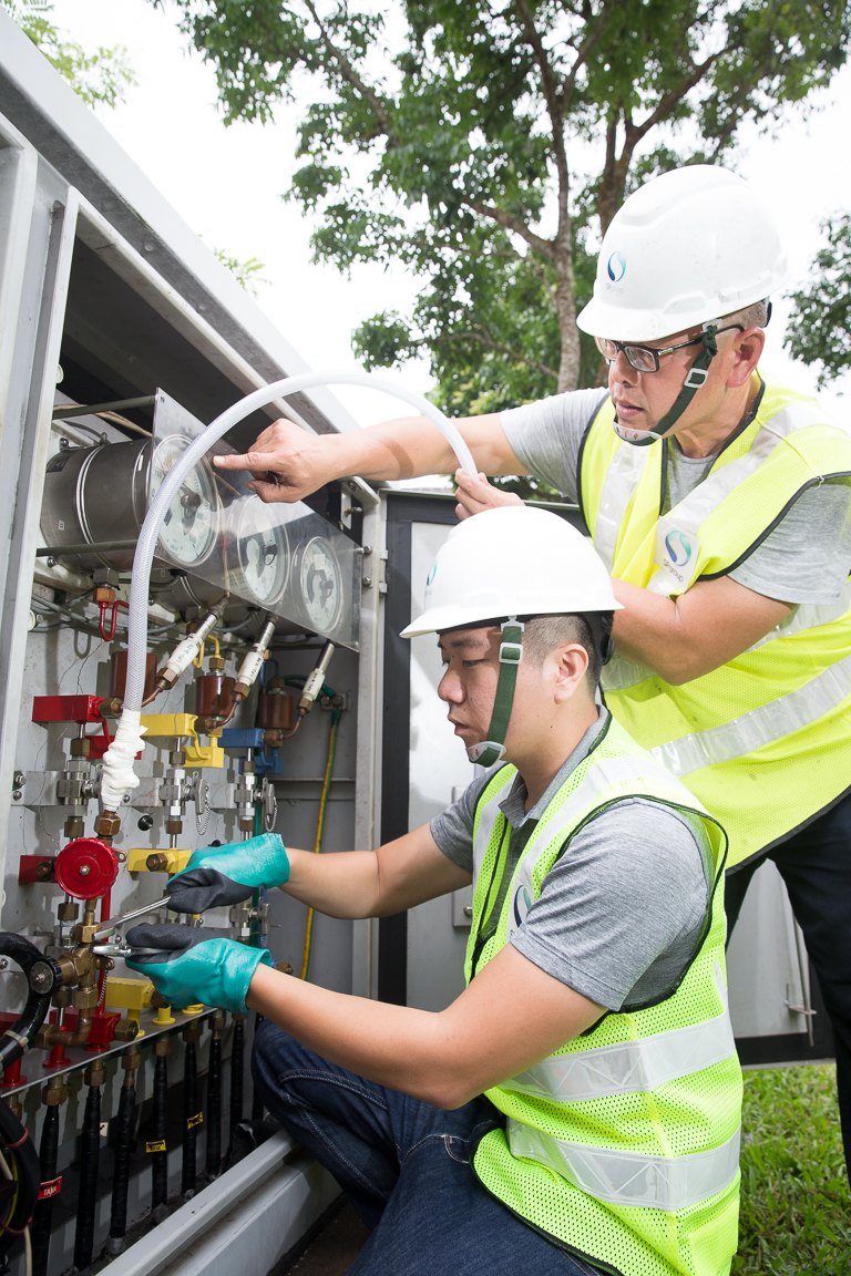 High voltage passion: Van (bottom) maintains transmission overground boxes such as the one above with his fellow cable jointer Mohammad Rosman B Abdul Wahab.